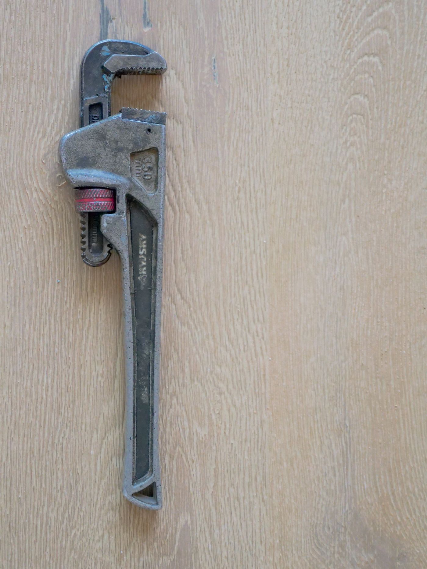 Pipe wrench on a wooden work surface