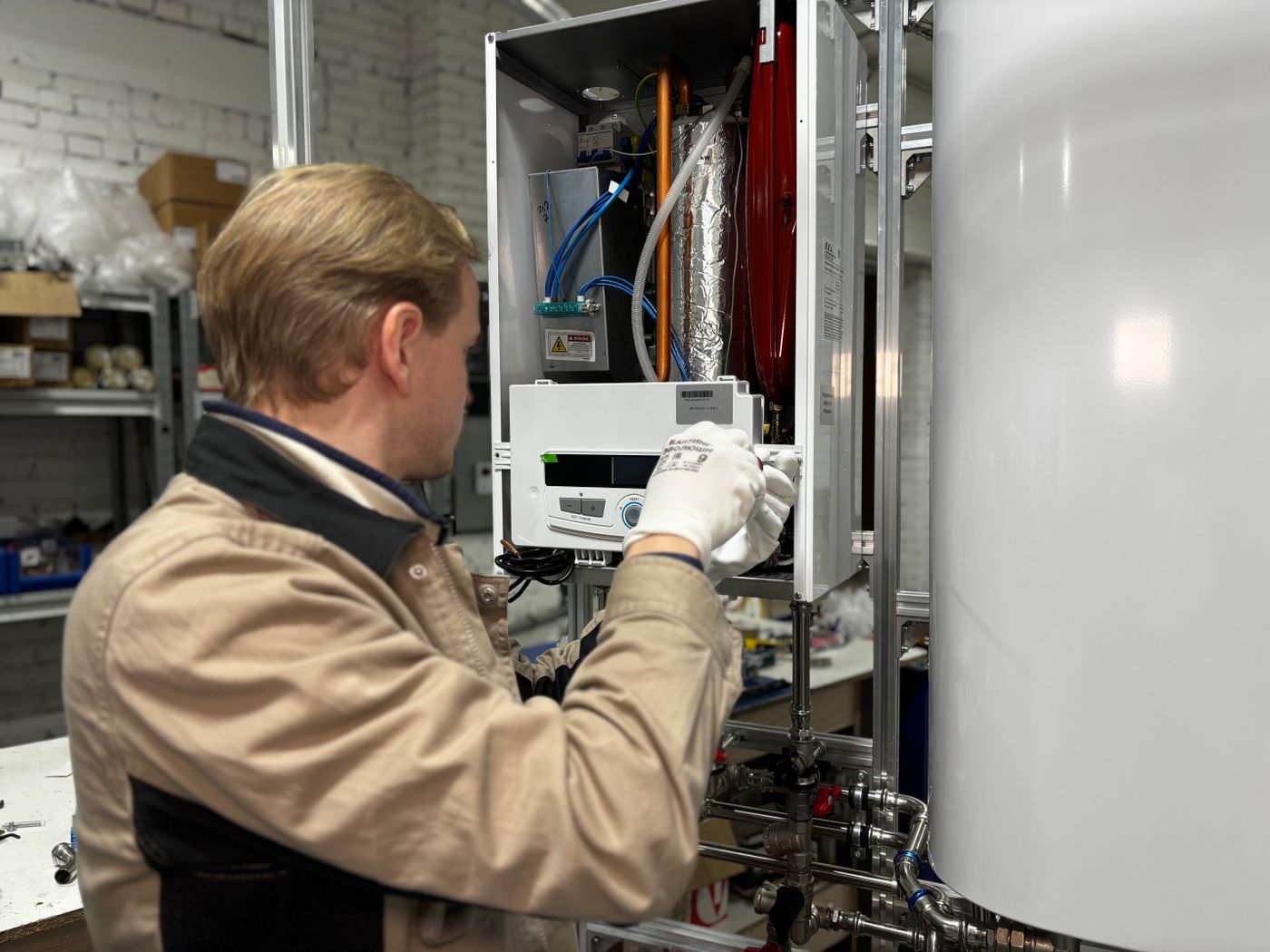 Technician servicing a wall-mounted water heating unit