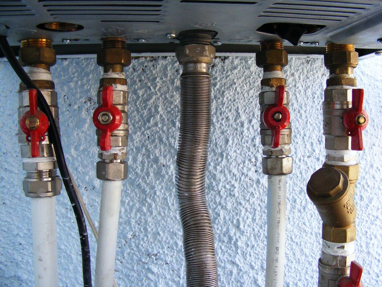 Shut-off valves and flexible gas line beneath a wall-mounted unit